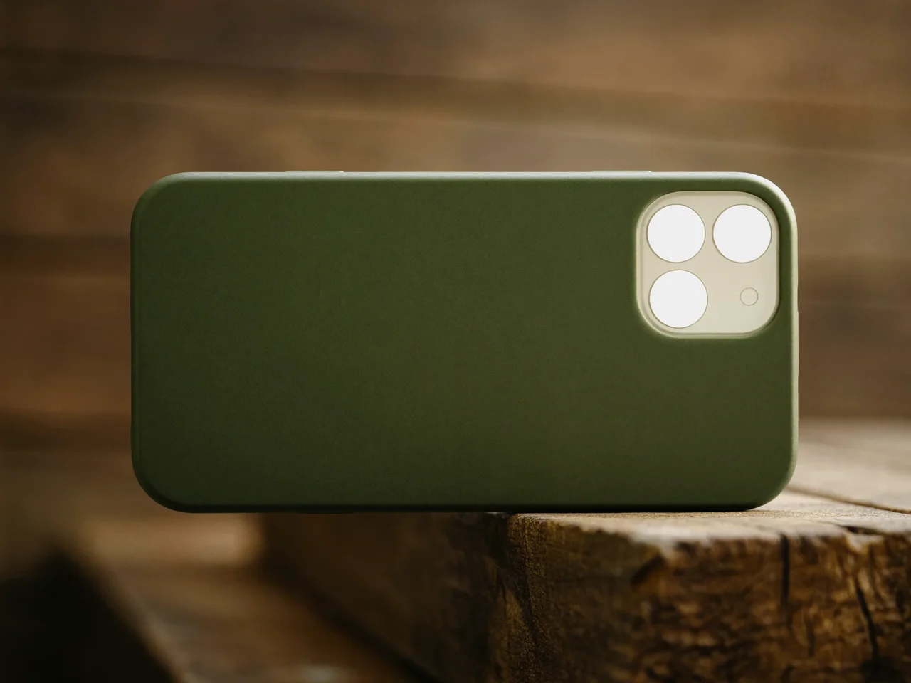 Husă mată din silicon verde de mușchi, pe lemn brut, în lumină naturală
